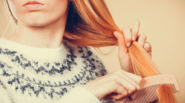 Blond tienermeisje borstelen van haar haren met kam — Stockfoto