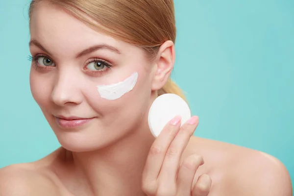 Mujer quitando maquillaje con crema y almohadilla de algodón — Foto de Stock