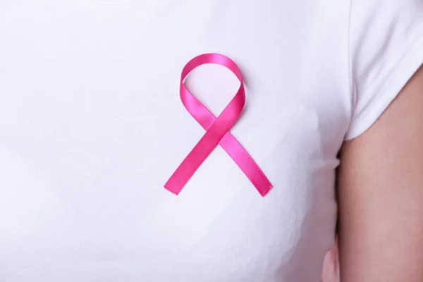 Ruban rose sur la poitrine de la femme pour soutenir la cause du cancer du sein — Photo