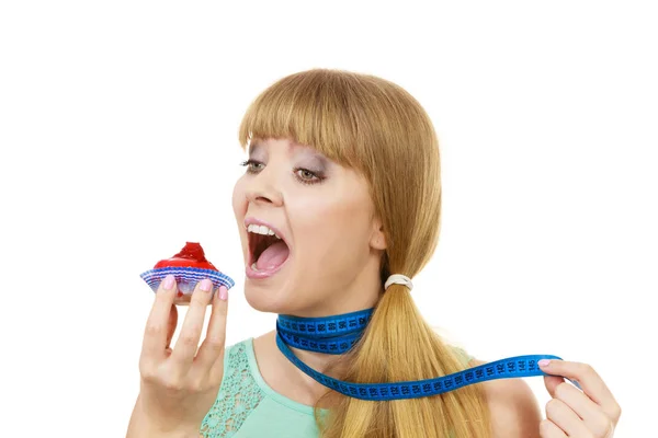 Mulher segura cupcake tentando resistir à tentação — Fotografia de Stock