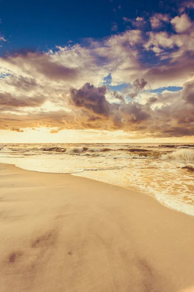 Mooie zonsondergang met wolken boven zee en strand — Stockfoto