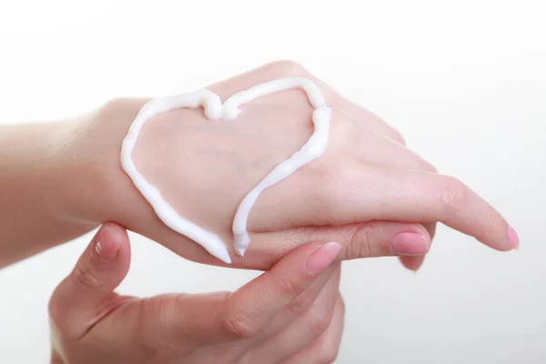 Cream on woman hand, heart shape — Stock Photo, Image
