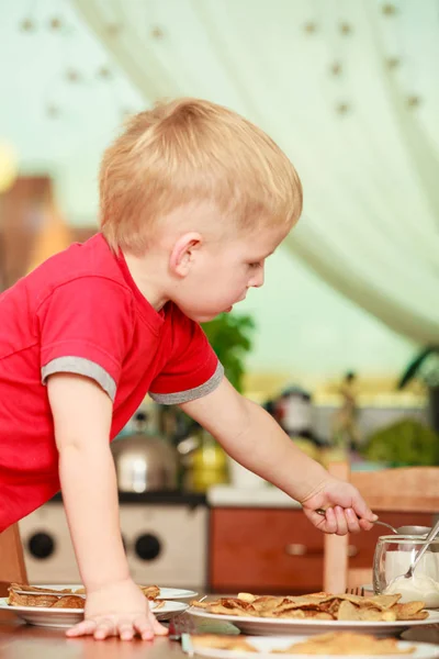 Kleiner Junge bereitet Pfannkuchen für das Frühstück zu — Stockfoto