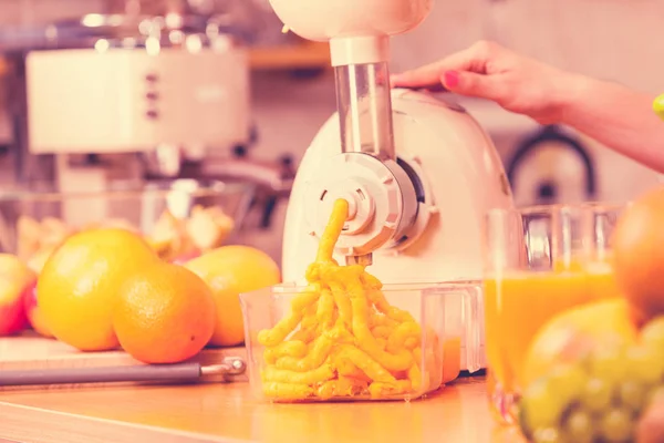 Donna che fa succo d'arancia in macchina spremiagrumi — Foto Stock