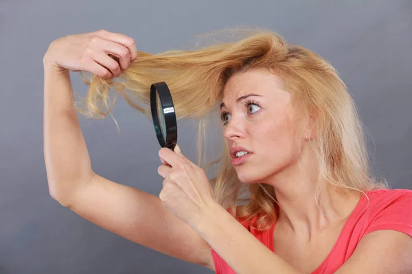 Mujer mirando el cabello a través de lupa — Foto de Stock