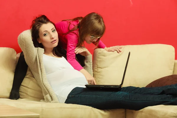 Mulher grávida e filha sentados com laptop — Fotografia de Stock