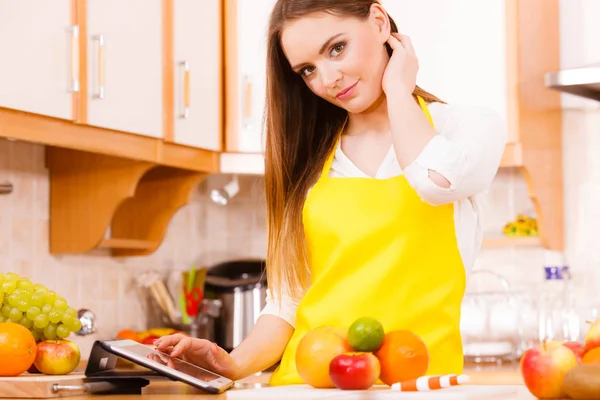 Mulher dona de casa na cozinha usando tablet — Fotografia de Stock