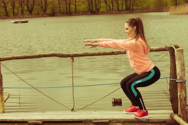 Chica de entrenamiento en ropa deportiva en la orilla del lago — Foto de Stock