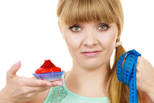 Woman holds cupcake trying to resist temptation — Stock Photo, Image