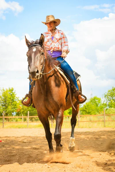 Cowgirl gör häst ridning på landsbygden äng — Stockfoto