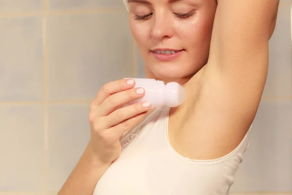 Woman applying stick deodorant in armpit — Stock Photo, Image