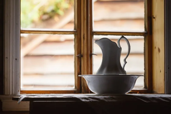 Old vintage window, ceramic jug in foreground — Stock Photo, Image