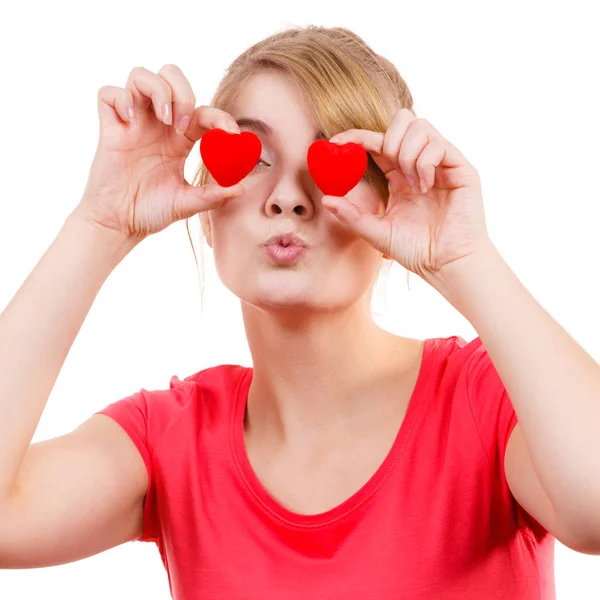Mujer divertida sostiene corazones rojos sobre los ojos — Foto de Stock