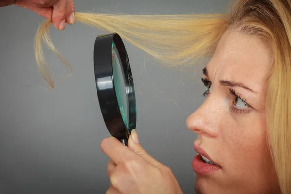 Mulher olhando para o cabelo através de lupa — Fotografia de Stock