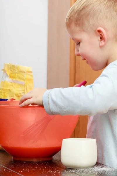 Niño pequeño cocinando, haciendo pastel en un tazón — Foto de Stock