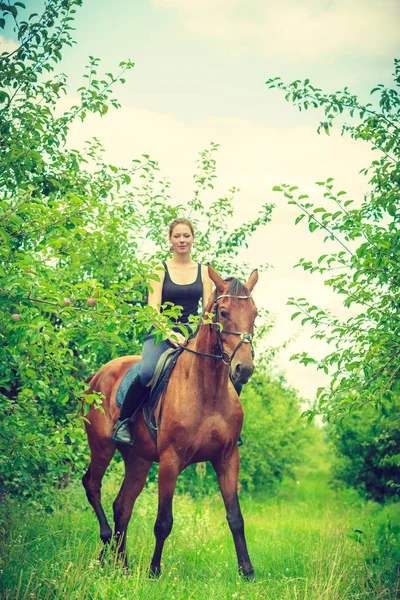 Jonge vrouw bevrijden op een paard — Stockfoto