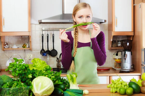 Kvinnelig husmor på kjøkkenet med grønne grønnsaker – stockfoto