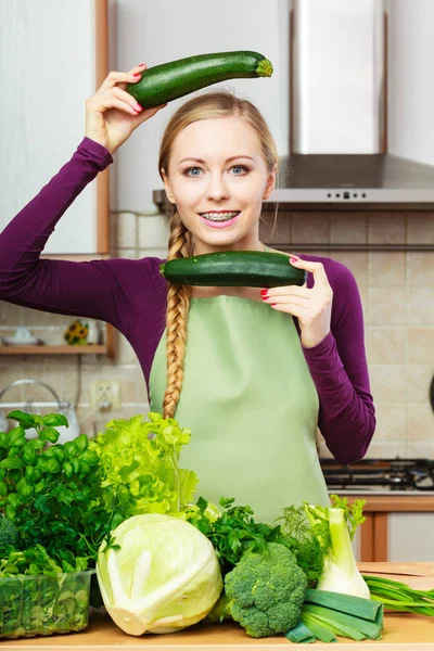 Mulher dona de casa na cozinha com legumes verdes — Fotografia de Stock