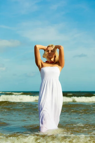 Blondynka w sukience chodząca w wodzie — Zdjęcie stockowe