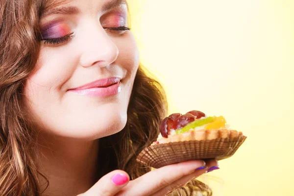 Vrouw gesloten ogen houdt taart in de hand — Stockfoto