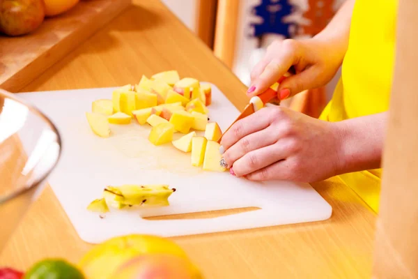 Mujer ama de casa en cocina cortando frutas de manzana —  Fotos de Stock