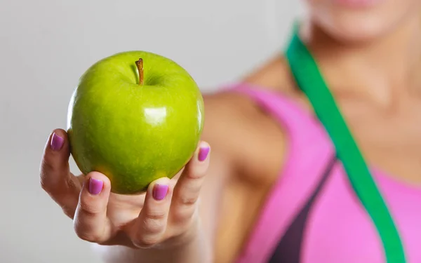 Žena fit dívka s opatřením pásky a apple ovoce — Stock fotografie