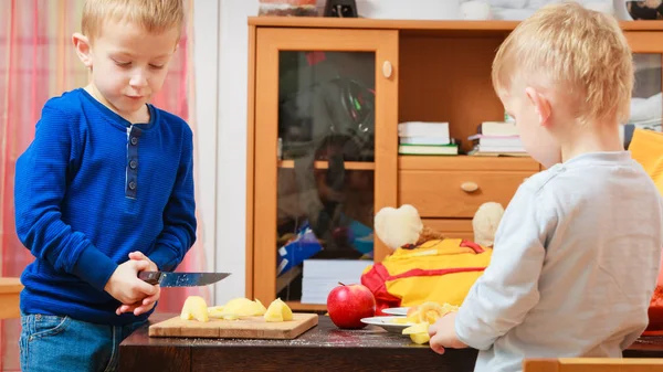 Two boys peeling apples and eating — Stock Photo, Image