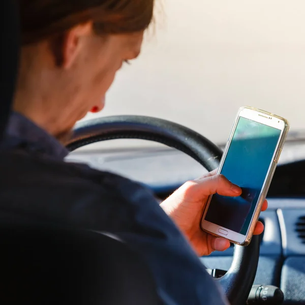 Mann benutzt Handy während Autofahrt. — Stockfoto