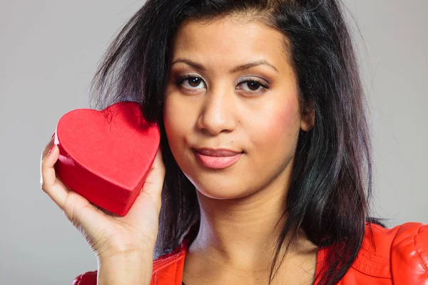 Девушка в красном держит подарок сердца — стоковое фото