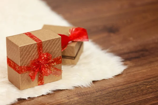 Twee gouden geschenkdozen met strik rood lint — Stockfoto