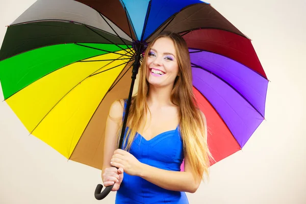 Frau im Sommerkleid hält bunten Regenschirm in der Hand — Stockfoto