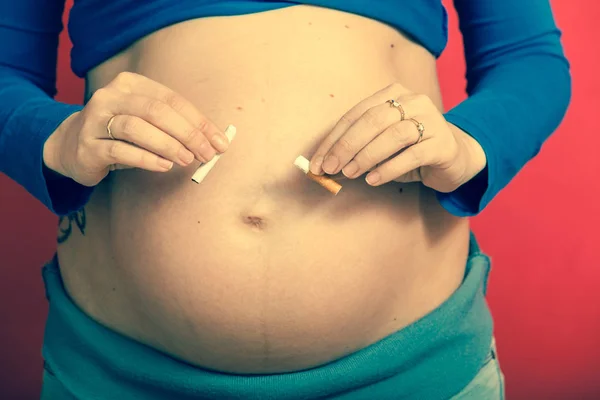 Mulher grávida com grande estômago quebrando cigarro — Fotografia de Stock