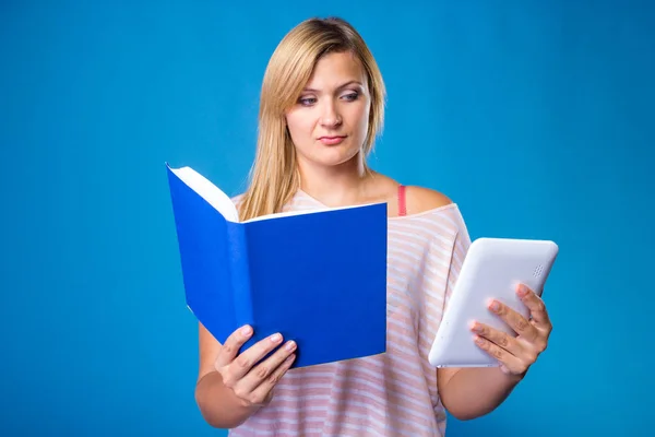 Mulher loira escolhendo entre livro e tablet — Fotografia de Stock