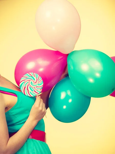 Γυναίκα κατέχει πολύχρωμα μπαλόνια και γλειφιτζούρι — Φωτογραφία Αρχείου