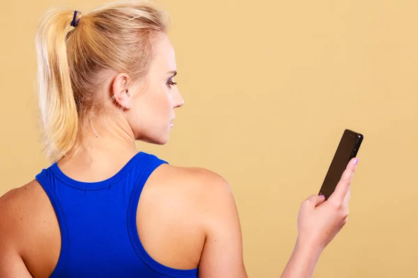 Deportiva usando teléfono móvil en el gimnasio . —  Fotos de Stock