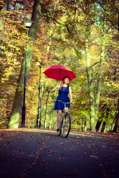 Wspaniała dziewczyna jazda na rowerze z parasolem. — Zdjęcie stockowe