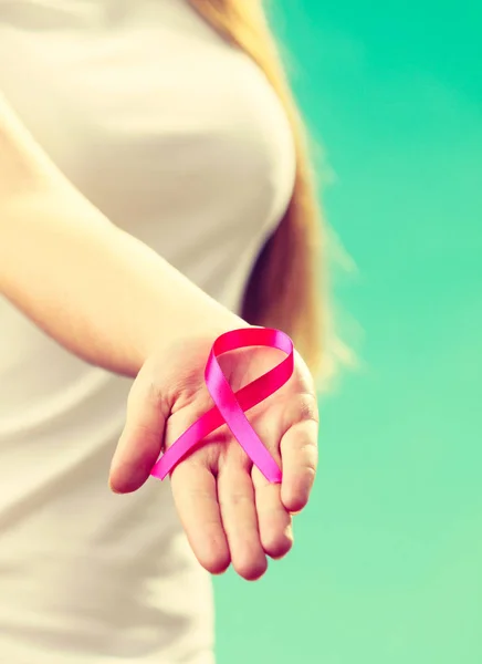 Mujer con el cáncer de mama cinta de conciencia en la mano — Foto de Stock