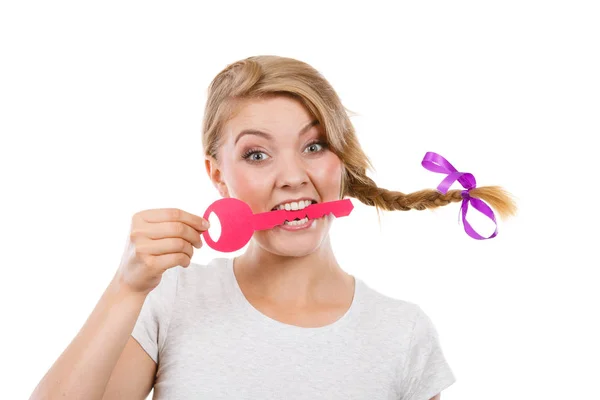 Teenage girl with braid biting key — Stock Photo, Image