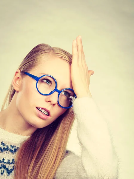 Nerd blond kvinna håller handen på pannan — Stockfoto