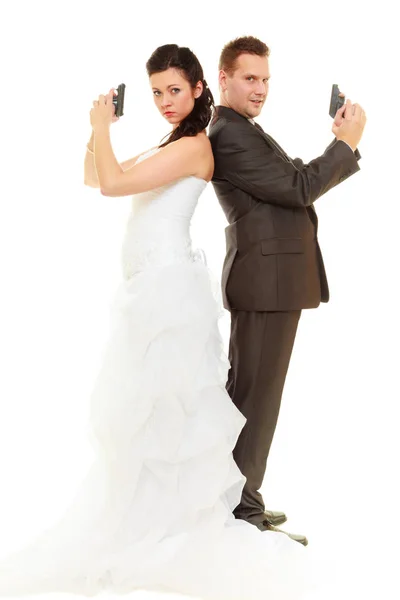 Bruid en bruidegom in bruiloft outfit houden geweren — Stockfoto