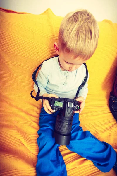 Enfant jouant avec un grand appareil photo numérique professionnel — Photo