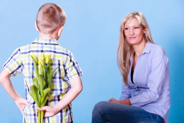 Little boy with mother hold flowers behind back. — Stock Photo, Image