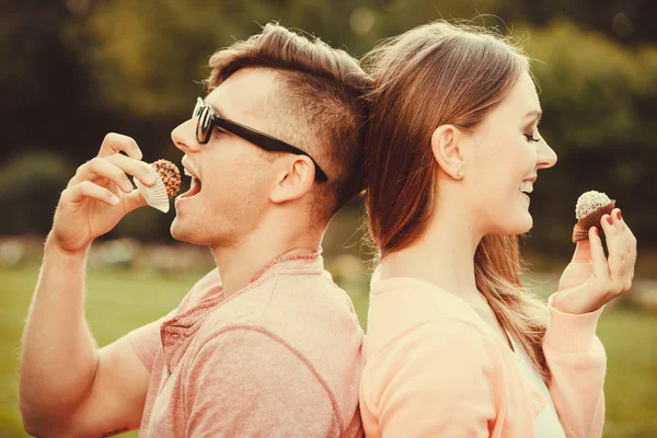 Hermosa pareja comiendo cupcakes . —  Fotos de Stock