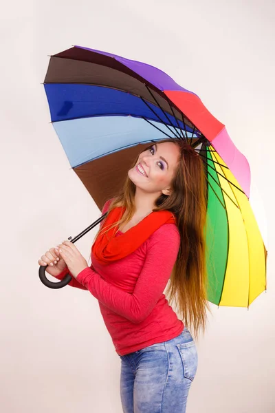 Женщина, стоящая под разноцветным зонтом — стоковое фото
