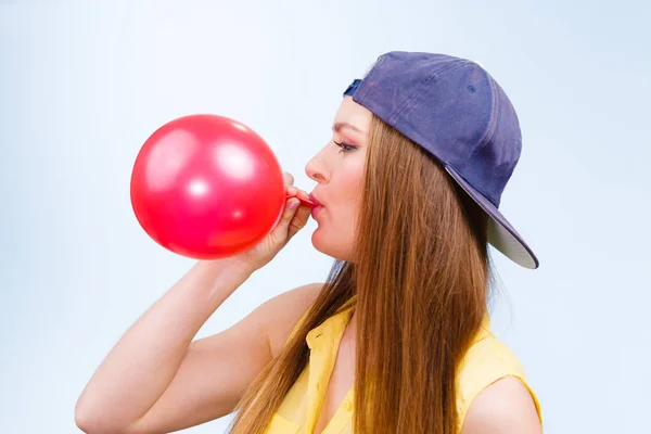 Adolescente feminina inflando balão vermelho . — Fotografia de Stock