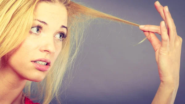 Mulher infeliz olhando para o cabelo destruído — Fotografia de Stock