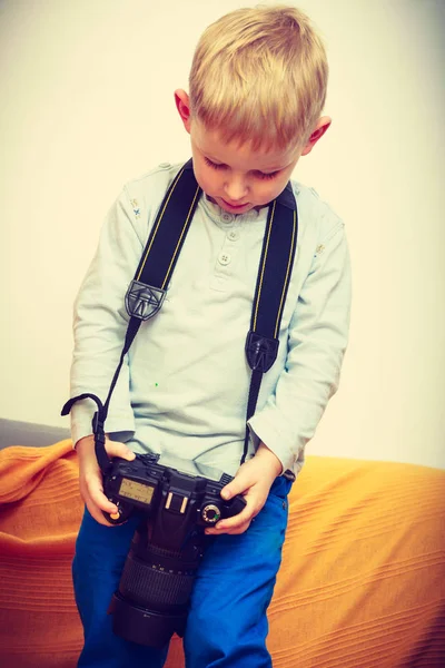 Kid playing with big professional digital camera — Stock Photo, Image