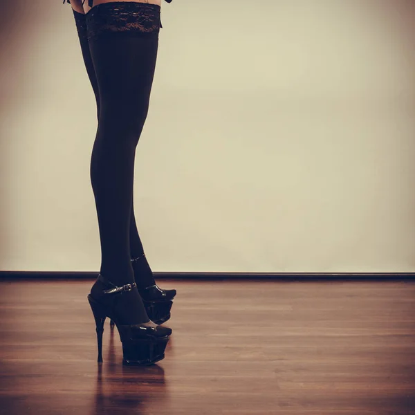 Sexy lange vrouwelijke benen in zwart. — Stockfoto