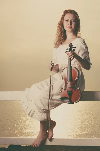 Donna sul molo fuori che tiene il violino — Foto Stock