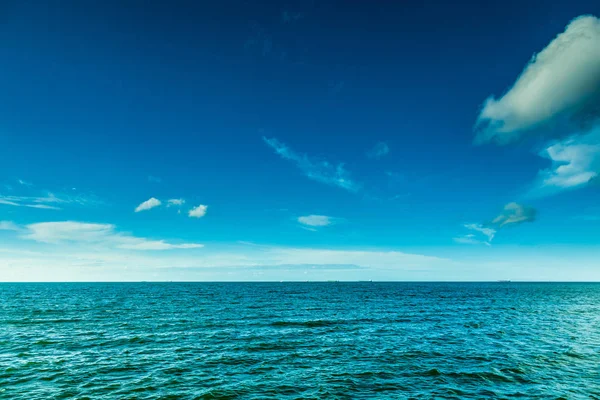 Синий океан и солнечное небо с облаками — стоковое фото